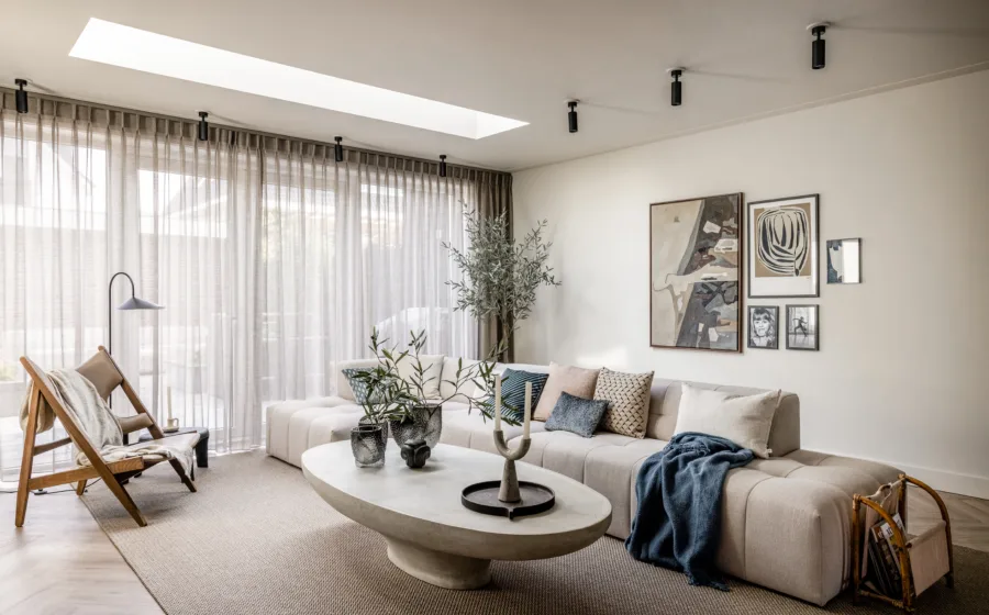 Hotel chic woonstijl met gordijnen, visgraat vloer en vloerkleed in de woonkamer