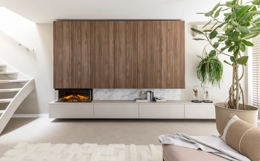Woonkamer met kast op maat in walnoot kleur inclusief gezellige elektrische haard en veel opbergruimte voor een strakke look.
