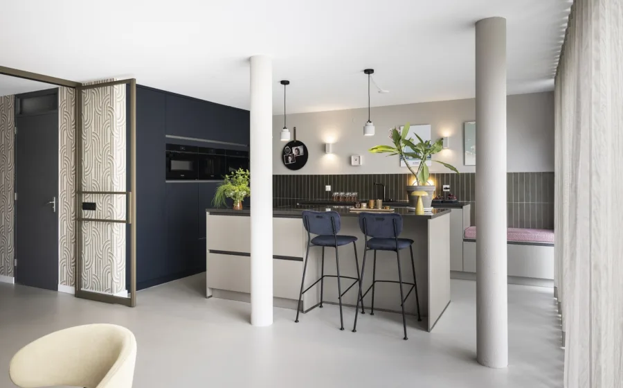 Vintage modern woonstijl donkerblauwe keuken met lichte betonlook vloer