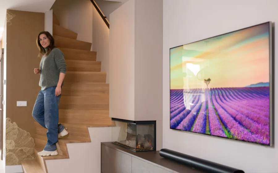 Vrouw op licht eiken Z-trap in de woonkamer