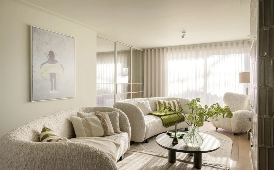 Luxe woonkamer met crème kleurige gordijnen voor veel daglicht.