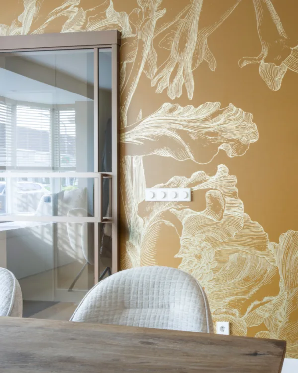 Oker geel Kek behang met gouden details en stalen deur brons