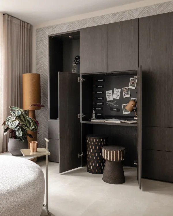 Woonkamer met wandkast op maat in donkere houtlook.