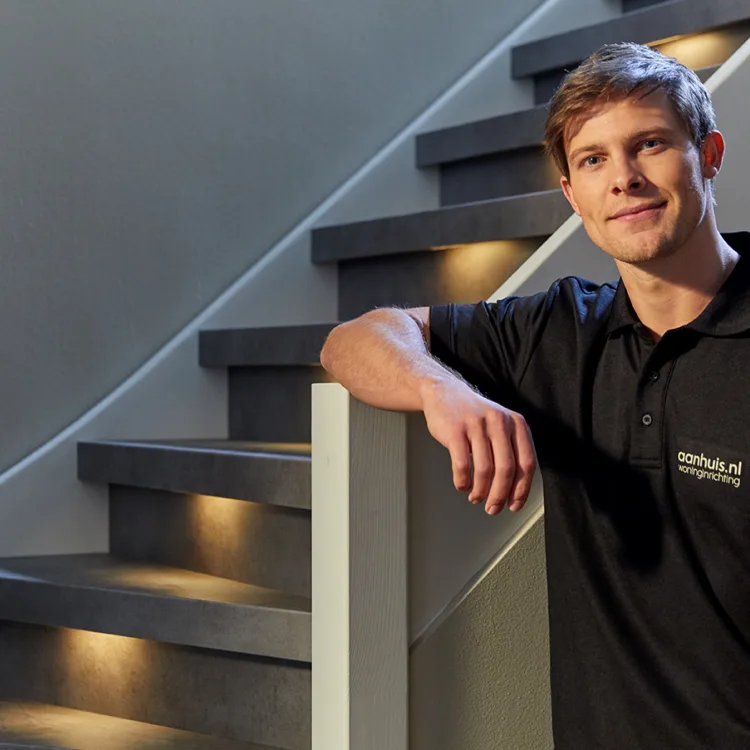 Aanhuis vakman bij donkere trap met ledverlichting
