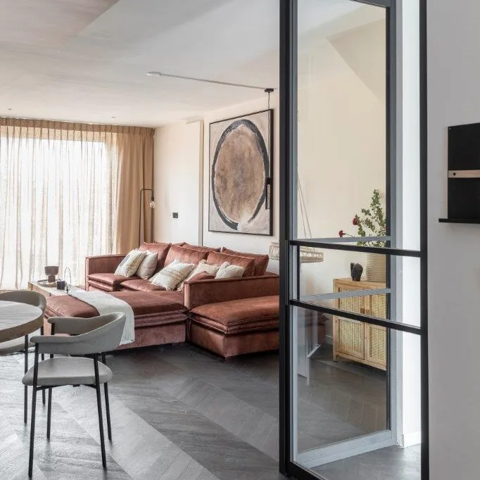 zwarte visgraat vloer en stalen deur in de woonkamer