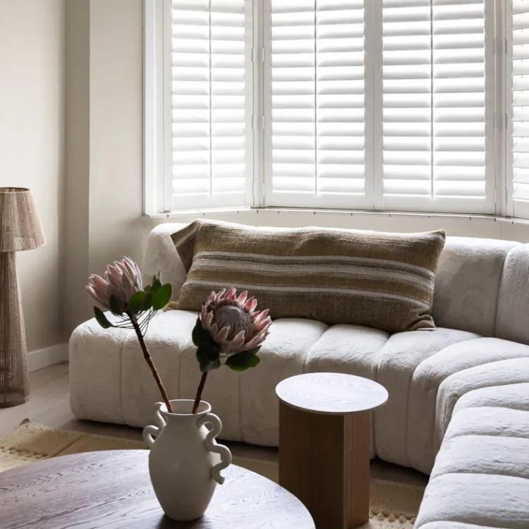 Basic naturel woonstijl met witte shutters in de woonkamer